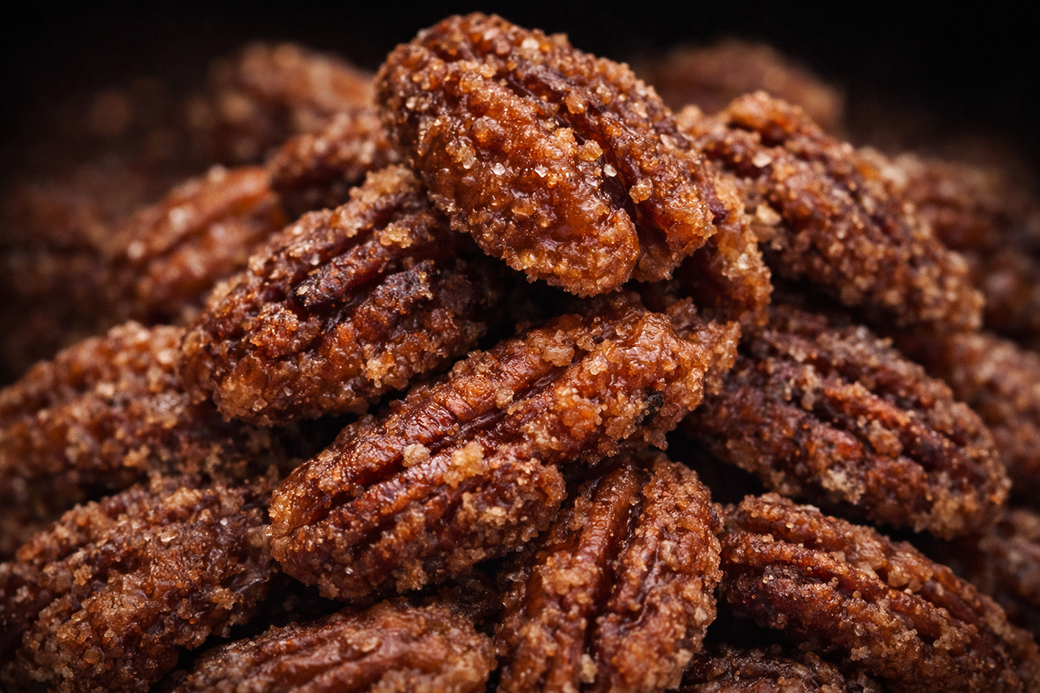 Close-up of roasted pecans with a dark background